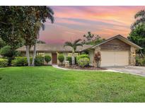 Charming single-story home with a well-manicured lawn and tropical landscaping at 7401 3Rd Nw Ave, Bradenton, FL 34209
