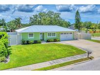 Charming single story home featuring a metal roof, lush lawn and beautiful landscaping at 7727 9Th Avenue Nw Dr, Bradenton, FL 34209
