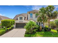 Charming two-story home featuring a well-manicured lawn, lush landscaping, and an attached two-car garage at 843 Molly Cir, Sarasota, FL 34232