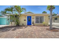 Charming home with a bright blue door, lush landscaping, and a brick driveway at 1116 S Moonmist Ct # M12, Sarasota, FL 34242