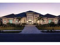 Stunning home exterior featuring a symmetrical design, manicured landscaping, and a welcoming entrance at twilight at 1162 Blue Shell Loop, Sarasota, FL 34240