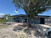 Charming single-story home featuring a covered carport and mature trees in the front yard at 1506 S 78Th S St, Tampa, FL 33619