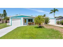Charming single-story home with a well-maintained lawn, an attached garage, and beautiful turquoise trim at 320 59Th W St, Bradenton, FL 34209