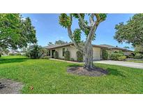Charming single-story home featuring a well-manicured lawn and a mature tree, offering curb appeal and shade at 3734 Ballantrae Dr # 19D, Sarasota, FL 34238