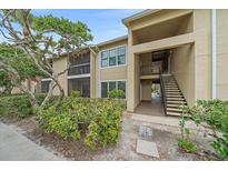 Tan condo building with a combination of screened balconies and stairwell access for upper levels at 4057 Crockers Lake Blvd # 15, Sarasota, FL 34238