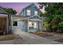Charming blue two-story home with a welcoming front porch and a convenient carport at 412 E Amelia Ave, Tampa, FL 33602