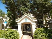 Inviting entrance to the building featuring beautiful landscaping and shaded walkway for residents and guests at 5146 Northridge Rd # 310, Sarasota, FL 34238