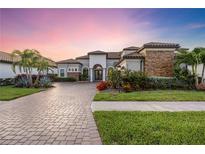 Luxury home showing landscaping and a paver driveway as well as a grass lawn at 5328 Brookgrove Dr, Sarasota, FL 34238