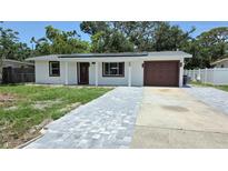 Charming single-story home with a gray paver driveway and a one-car garage at 6404 8Th Street W Ct, Bradenton, FL 34207