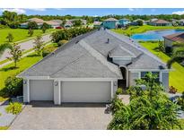 Beautiful single-Gathering home with a large gray roof, three-car garage, and well-manicured landscaping with a lake view at 650 Rosemary Cir, Bradenton, FL 34212