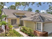 Charming single-story home with tile roof, landscaped front yard, and inviting walkway, blending beauty and functionality at 7617 Whitebridge Gln, University Park, FL 34201