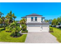Beautiful two-story home with a three car garage, tropical landscaping, and a brick paver driveway at 826 Honeyflower Loop, Bradenton, FL 34212