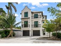 Modern two-story home with two-car garage, balconies, and sleek, minimalist design at 128 Fillmore Dr, Sarasota, FL 34236