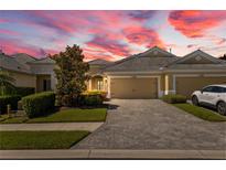 Inviting home featuring manicured landscaping, a paver driveway, and an attached two-car garage at 2070 Crystal Lake Trl, Bradenton, FL 34211