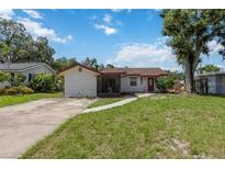 Quaint single-story home featuring a red door and a classic concrete driveway at 2558 Hawthorne St, Sarasota, FL 34239