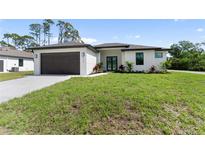 Charming single-story home with a well-manicured lawn and a two-car garage at 2664 Hagerick Ln, North Port, FL 34288