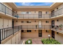 Multi-level condo building showcasing a courtyard, exterior walkways, and balconies for each unit at 2763 Woodgate Ln # 211, Sarasota, FL 34231