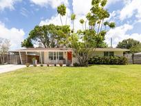 Charming single-story home featuring a well-manicured lawn and colorful landscaping at 2933 Michigan St, Sarasota, FL 34237