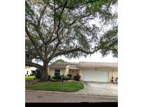 Charming single story home with an attached garage, walkway, and a shade tree in a well-maintained front yard at 4131 Oakhurst W Cir # 3133, Sarasota, FL 34233