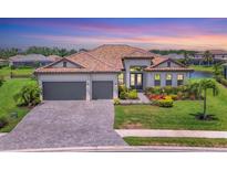 Beautiful single-Gathering home featuring a tile roof, three-car garage, and well-manicured landscaping in a serene community at 4925 Coastal Days Ln, Bradenton, FL 34211