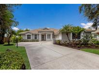 Charming single-story home with a well-manicured lawn, mature landscaping, and spacious driveway at 4998 Cedar Oak Way, Sarasota, FL 34233