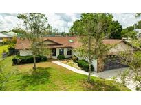 Charming home featuring a well-maintained lawn, mature trees, and a stone-accented two-car garage at 5213 20Th Street E Ct, Bradenton, FL 34203