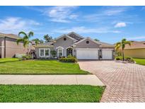 Charming single-story home boasts a well-manicured lawn, brick driveway, and a three-car garage at 5515 69Th E Pl, Ellenton, FL 34222