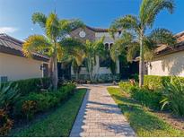Stunning home featuring lush landscaping, a paver walkway, and a charming stone accent facade at 5604 Palmer Cir # 103, Bradenton, FL 34211
