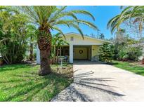 Charming single-story home with a carport, lush landscaping, and mature palm trees at 681 Fox St, Longboat Key, FL 34228