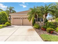 Charming single-story home featuring a two-car garage and tropical landscaping, creating an inviting curb appeal at 7343 Birds Eye Ter, Bradenton, FL 34203