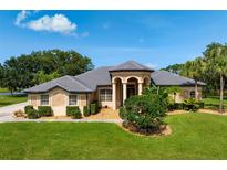Stunning single story home with well manicured lawn, lush landscaping, and charming covered front porch at 8312 Misty Lake Cir, Sarasota, FL 34241