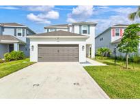 Beautiful two-story home featuring a neutral color scheme, lush lawn, and a two-car garage at 9040 Tequila Sunrise Dr, Sarasota, FL 34241