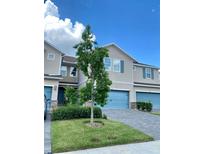 Charming townhome with a blue garage door, stone accents, and well-maintained landscaping at 11613 Woodleaf Dr, Lakewood Ranch, FL 34211