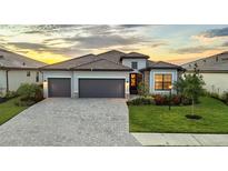 Stunning single-Gathering home boasts a paver driveway, manicured lawn, and a three-car garage at 15344 Serene Shores Loop, Bradenton, FL 34211