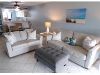 Cozy living room featuring comfortable seating, an ottoman, and a beach-themed painting at 1801 Gulf N Dr # 207, Bradenton Beach, FL 34217