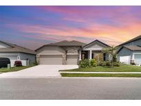 Charming single-Gathering home with a three-car garage, stone accents, and well-manicured landscaping at 2108 Citrus Breeze Dr, Bradenton, FL 34208