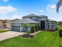 Beautiful two-story home with lush landscaping, a three-car garage, and a well-manicured lawn at 2347 123Rd E Pl, Parrish, FL 34219