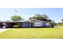 Charming single-story home featuring a carport, well-kept lawn and an American flag waving proudly at 3727 Dover Dr, Sarasota, FL 34235