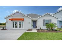 Charming single-story home with an orange awning, blue door, and freshly manicured lawn at 4425 Boxelder Avenue, Parrish, FL 34219