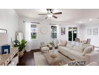 Bright living room featuring hardwood floors, natural light, and a comfortable seating arrangement at 4617 Garden Arbor Way, Bradenton, FL 34203
