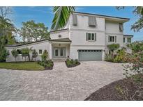 Elegant two-story home with a paved driveway, well-manicured landscaping, and a modern architectural design at 4831 Primrose Path, Sarasota, FL 34242