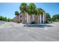 Inviting condo complex featuring palm trees, manicured landscaping, and convenient parking at 519 Albee Farm Rd # 212, Venice, FL 34285
