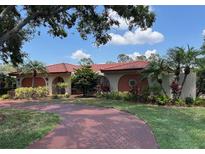 Charming one-story home with a red tile roof, arched entryway and meticulously landscaped front yard at 5349 Everwood Run, Sarasota, FL 34235