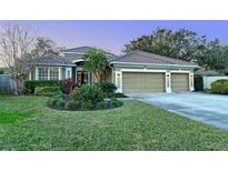 Beautiful home featuring a three-car garage, a well-manicured lawn, and a tile roof at 5401 Oak Grove Ct, Sarasota, FL 34233