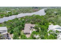 Stunning aerial view of home surrounded by lush greenery and waterfront views at 5935 River Forest Cir, Bradenton, FL 34203