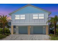 Inviting elevated beach house with blue shingle roof and two-car covered parking at 616 Fern St, Anna Maria, FL 34216