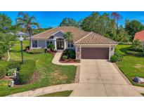 Stunning single-story home with a tile roof, mature landscaping, and an attached two car garage at 7302 Dunes Ct, Bradenton, FL 34202