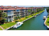 Waterfront condos with a boat slip, featuring lush landscaping and direct access to beautiful waterways at 1300 N Portofino Dr # 103, Sarasota, FL 34242