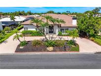 Elegant home featuring a red tile roof, lush landscaping, and a brick-paved driveway, offering curb appeal at 1484 Seafarer Dr, Osprey, FL 34229