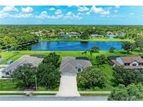 Beautiful aerial view of home with a spacious yard and a serene lake in the backyard at 208 147Th Ne St, Bradenton, FL 34212